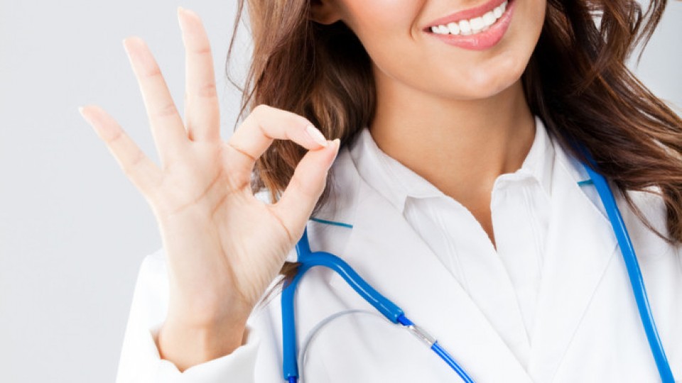Female doctor with okay gesture, over grey